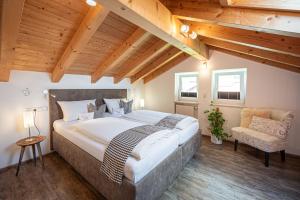 a bedroom with a large bed and a chair at Alp-Chalet in Bolsterlang +22 photos