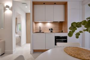 a kitchen with white cabinets and a table at Ancienne cave de pêcheur in La Ciotat