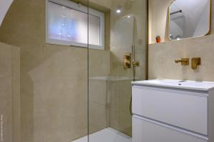 a bathroom with a glass shower and a sink at Ancienne cave de pêcheur in La Ciotat