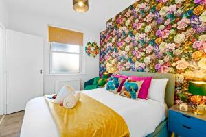 ein Schlafzimmer mit einem großen Bett mit einer Blumenwand in der Unterkunft Modern 1-Bed Serviced Apartment - Central Brighton in Brighton & Hove