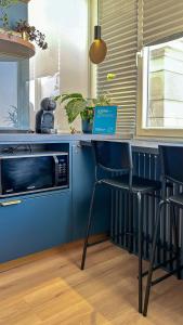 a kitchen with a blue counter and a microwave at Aozora Central Studio in Bucharest