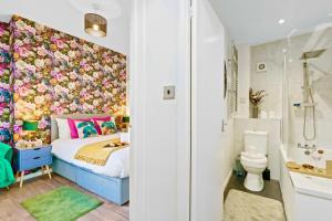 ein Schlafzimmer mit einem Bett mit einer Blumenwand in der Unterkunft Modern 1-Bed Serviced Apartment - Central Brighton in Brighton & Hove + 30 Fotos