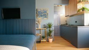 a room with a kitchen and a bedroom with a bed and a kitchen at Aozora Central Studio in Bucharest