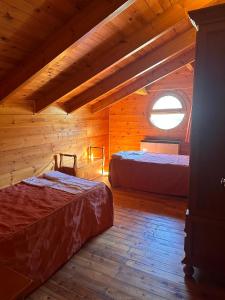 a bedroom with two beds in a wooden cabin at CASA DE MADERA ZUMACAR VI in Cazorla