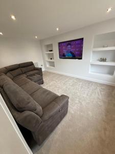 a living room with a couch and a flat screen tv at 3 Bed home in Lincolnshire in Wigtoft