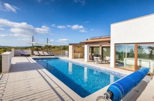 a swimming pool in the backyard of a house at Villa Mala Halu in Katun Gračanski