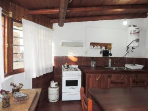 una cucina con piano cottura, lavandino e tavolo di Cabañas Gesell a Villa Gesell