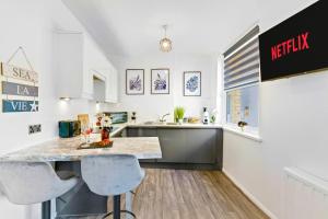 eine Küche mit Theke und zwei Barhockern in der Unterkunft Modern 1-Bed Serviced Apartment - Central Brighton in Brighton & Hove