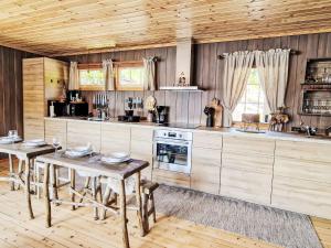 a kitchen with wooden cabinets and a table with chairs at Holiday Home Staksholmen by Interhome in Konsmo +31 photos