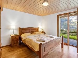 een slaapkamer met een bed en een groot raam bij Apartment Racer's Retreat Apt-07 by Interhome in Wengen