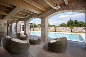 an outdoor patio with chairs and a swimming pool at Residence Monaco for 10 people in Central Istria with 65 m2 private pool, large garden & spa in Svetvinčenat +16 photos