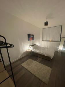 a white bedroom with a bed and a rug at Card House Apartment By DownTown Living in Saltaire