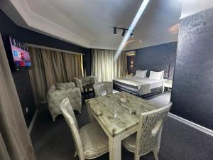a hotel room with a bed and a table and chairs at Amber Hotel in Baku