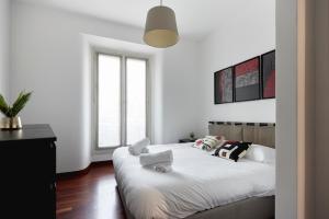 una camera da letto con due letti e una grande finestra di Cadorna CityView Flat - Strategic position in the middle of the Square a Milano