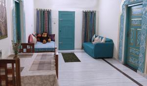 un soggiorno con divano blu e orsacchiotto di Gypsy Walker a Varkala