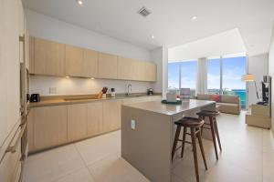 a kitchen with a counter and some stools in it at Beautiful Beachfront Penthouse in Hollywood