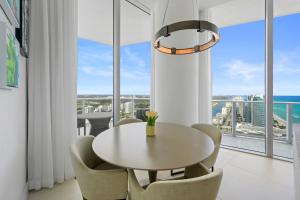 a dining room with a table and chairs and a large window at Beautiful Beachfront Penthouse in Hollywood