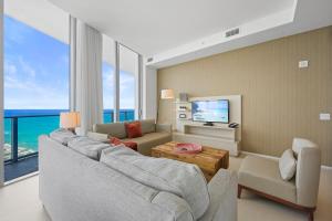 a living room with a couch and a tv at Beautiful Beachfront Penthouse in Hollywood