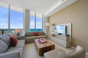 a living room with a couch and a tv at Beautiful Beachfront Penthouse in Hollywood