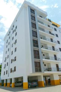 a white building with a car parked in front of it at Fully furnished apartment in Nyali near the beach in Mombasa