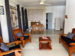 a living room with wooden furniture and a table at résidence fleur de canne in Mont Choisy
