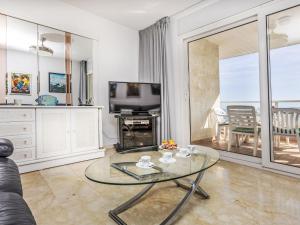 a living room with a glass table and a television at Apartment Blanes Beach by Interhome in Blanes