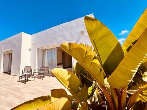 ein Haus mit einer großen gelben Blattpflanze davor in der Unterkunft Villa Petit Val d'Or - 3BR Comfort, and Beachside in Temara