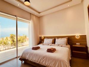 ein Schlafzimmer mit einem großen Bett mit zwei Handtüchern darauf in der Unterkunft Villa Petit Val d'Or - 3BR Comfort, and Beachside in Temara + 62 Fotos