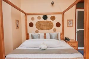 une chambre avec un grand lit avec une tête de lit en bois dans l'établissement Orlando Cottages, à Arusha 15 autres photos