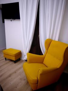 a yellow chair and a ottoman in a room at Casa Petrí Home SPA in Palermo +41 photos