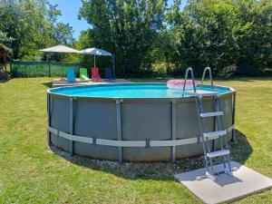a circular pool with a slide in the grass at Holiday Home Magdalena by Interhome in Potpićan