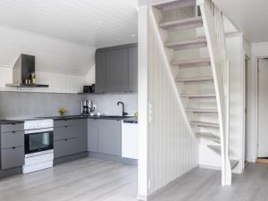 a kitchen with white cabinets and a spiral staircase at Holiday Home Lange by Interhome in Bømlo