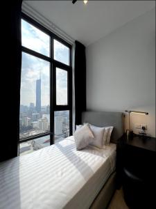 a bedroom with a bed and a large window at KL Suites Axon Residence - Wi-Fi 500Mbph in Kuala Lumpur