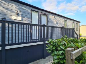 a house with a blue door and a fence at Heather William Luxury Lodge in Woodhall Spa in Woodhall Spa