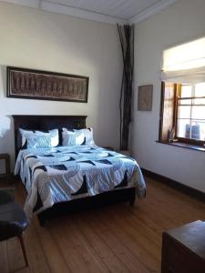 un dormitorio con una cama y una ventana en A2B Eco Farm, Byrne Valley, KZN, en Byrne