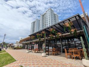 un ristorante con tavoli e sedie e un edificio alto di Jaco Beach, Viva Jaco, AC, HOT water, 3 Pools, BBQ, Rancho, Office, Gym a Jacó