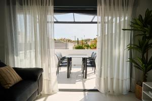 un soggiorno con tavolo, sedie e una finestra di Villa Carmen Albir a Albir