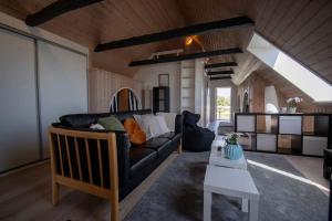 a living room with a black couch and a table at Villa Soldal in Sindal