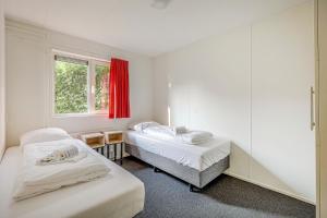two beds in a room with a window at Landgoed Leudal in Haelen