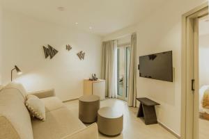 a living room with a couch and a tv at Opal Paros in Naousa