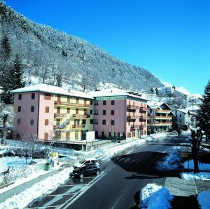 a car driving down a street with a mountain at Residence Stella Alpina in Aprica