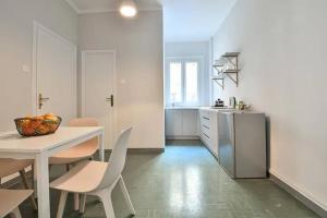 una cucina bianca con tavolo, sedie e bancone di Athenian Suite by Zeussuites ad Atene Altre 37 foto