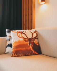 een kussen met een hert erop zittend op een bank bij Hotel Gasthof Mitteregger - BEST PLACE in town with summercard included in Kaprun