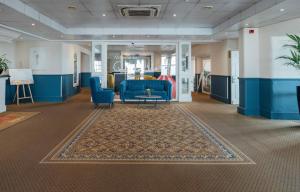 a lobby with a blue couch and chairs and a table at Queens Hotel & Spa in Brighton & Hove +134 photos