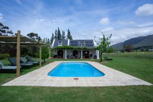 a swimming pool in the yard of a house at Raptor Rise Farm in Tulbagh