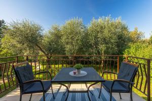 een tafel en stoelen op een balkon met bomen bij Casa Anka in Medulin