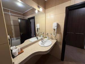 a bathroom with two sinks and a mirror at Мия4 Спа хотел Свети Спас in Velingrad