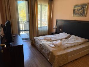 a bedroom with a bed with two towels on it at Мия4 Спа хотел Свети Спас in Velingrad