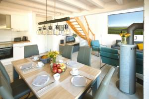 a kitchen and dining room with a wooden table and chairs at Blinkfüer in Nordhorn +20 photos