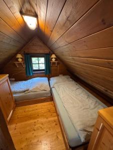 Postel nebo postele na pokoji v ubytování Ferienhaus Fischerhütte Rassis Feriendorf Donnersbachwald